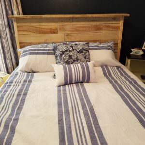 Just look at that wood grain! This clean design features the beautiful texture and uniqueness of pallet wood to create a centerpiece in your bedroom!